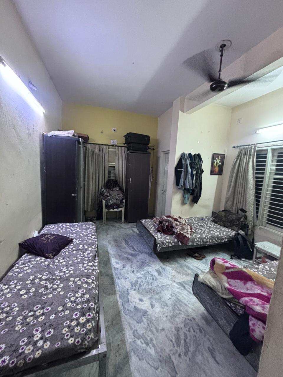 Budget sharing room with wardrobe and ceiling fan at Krushna Boys PG Navrangpura Ahmedabad