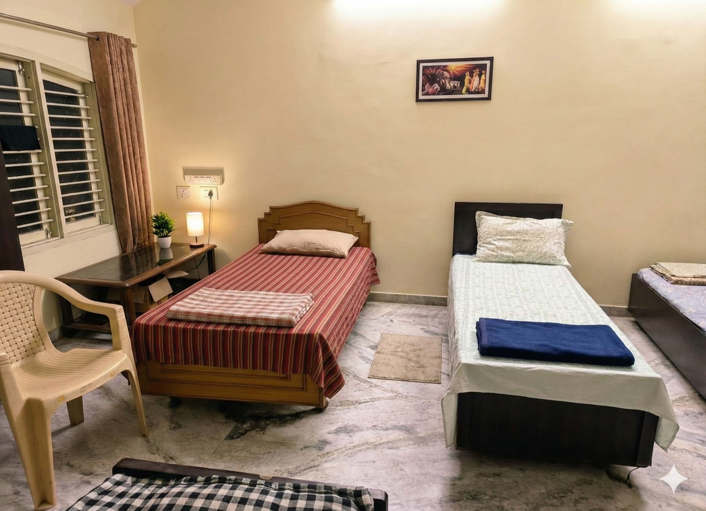 Furnished room with study desk and multiple beds at Krushna Boys PG for students in Navrangpura