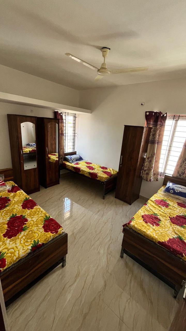 Triple sharing room at Krushna Boys PG with wardrobe, beds, and spacious layout in Navrangpura Ahmedabad